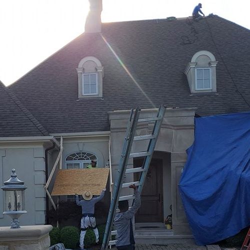Roofer tarps roof for emergency.