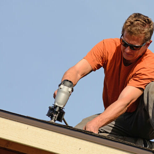 Roofer installs shingles.