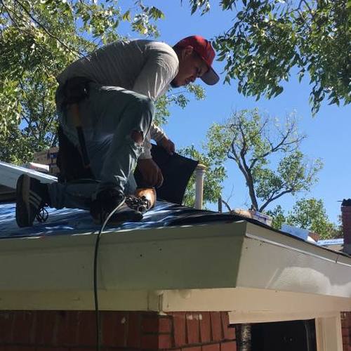 Roofer installs shingles.