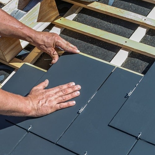 close-up of slate tile roofing being installed